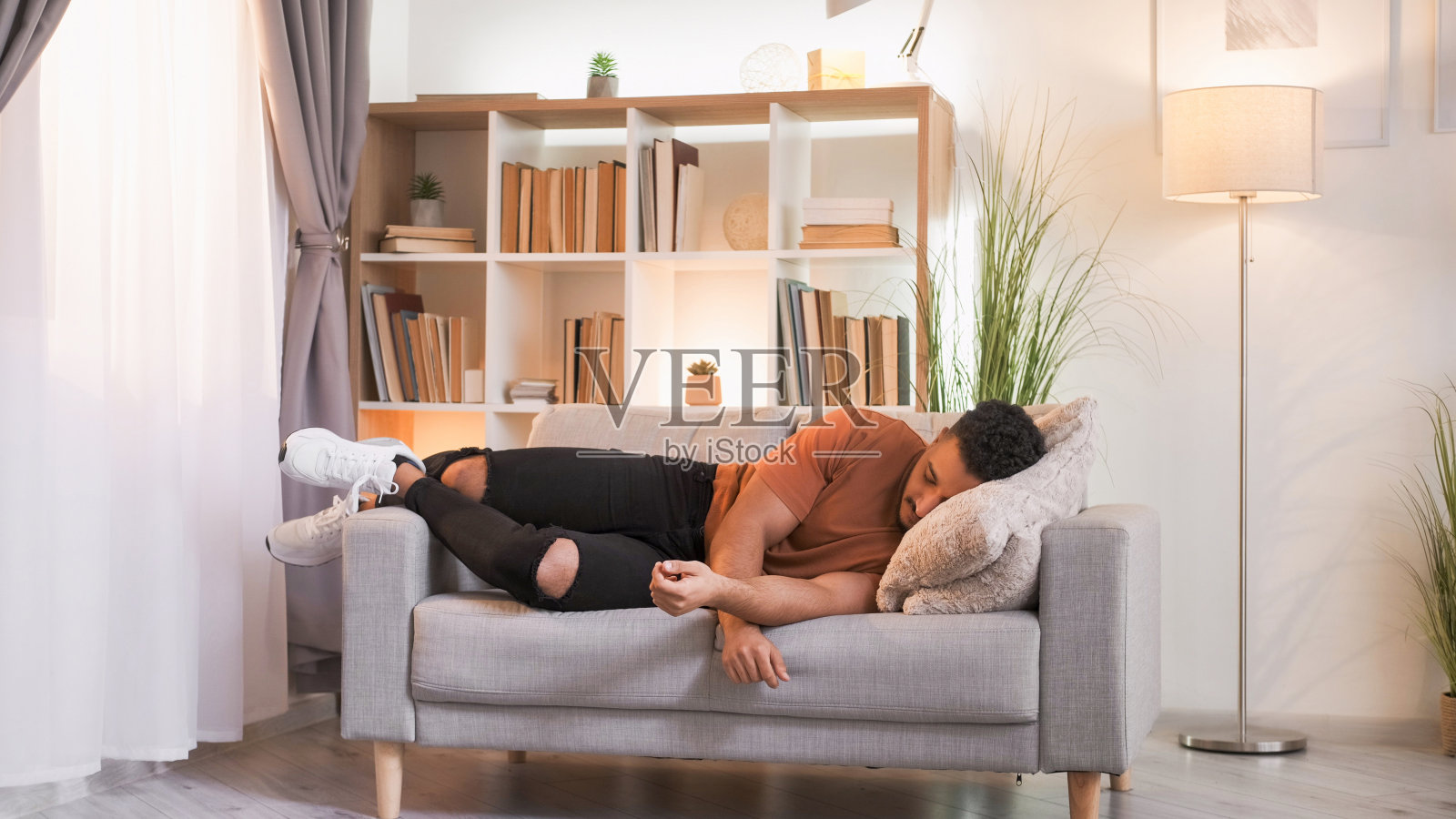 回家小睡周末休息累的家伙睡在沙发上照片摄影图片