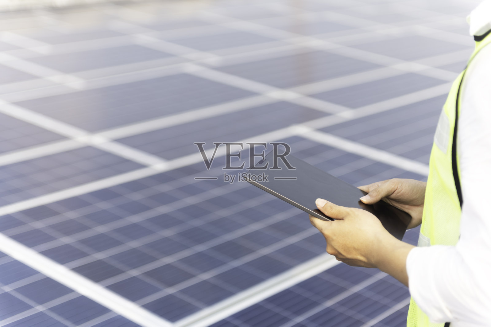 工程师服务检查安装在工厂屋顶上的太阳能电池。剪影技师在工厂屋顶检查和修理太阳能电池。照片摄影图片