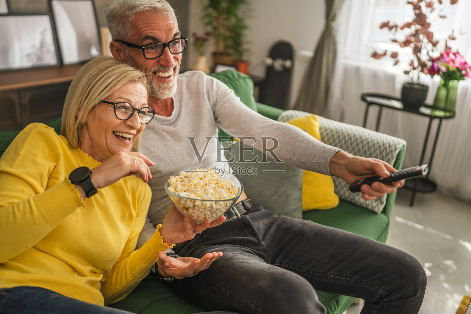成熟的老年夫妇夫妇看电影,吃爆米花照片摄影图片