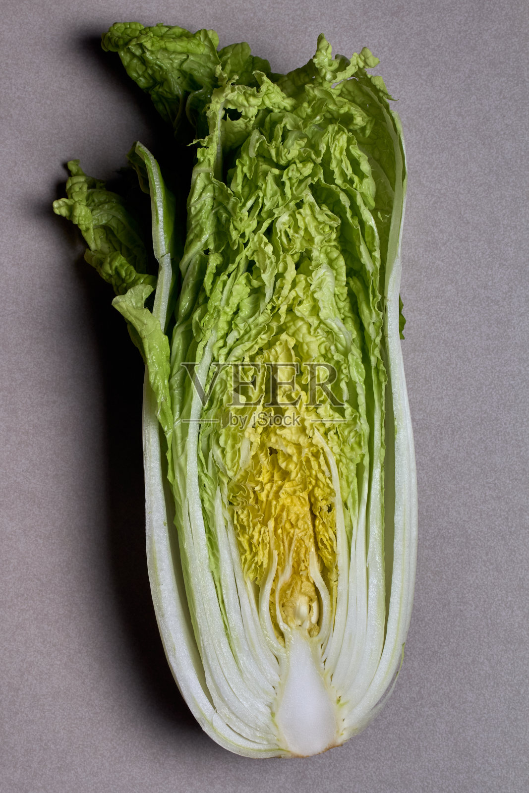 在灰色背景上切白菜。照片摄影图片