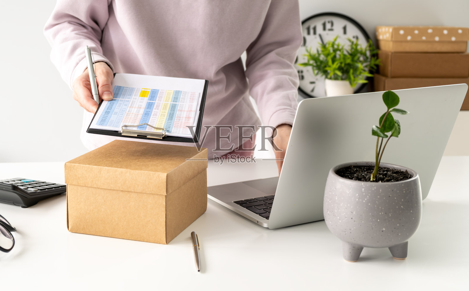 创业小型企业中小企业,企业家女老板使用智能手机或平板电脑接收和检查网上购物订单,准备包装产品盒。照片摄影图片