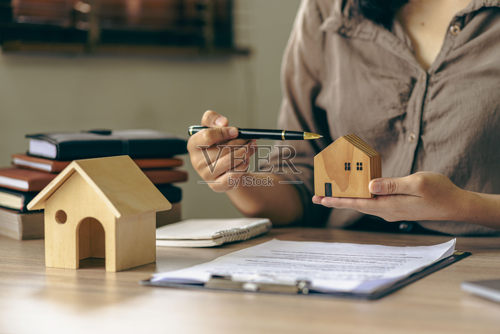 房地产经纪人,房屋模型,房屋特写,钥匙和桌子上的小玩具屋,律师,法律顾问,房地产经纪人,银行经理,签订抵押协议照片摄影图片