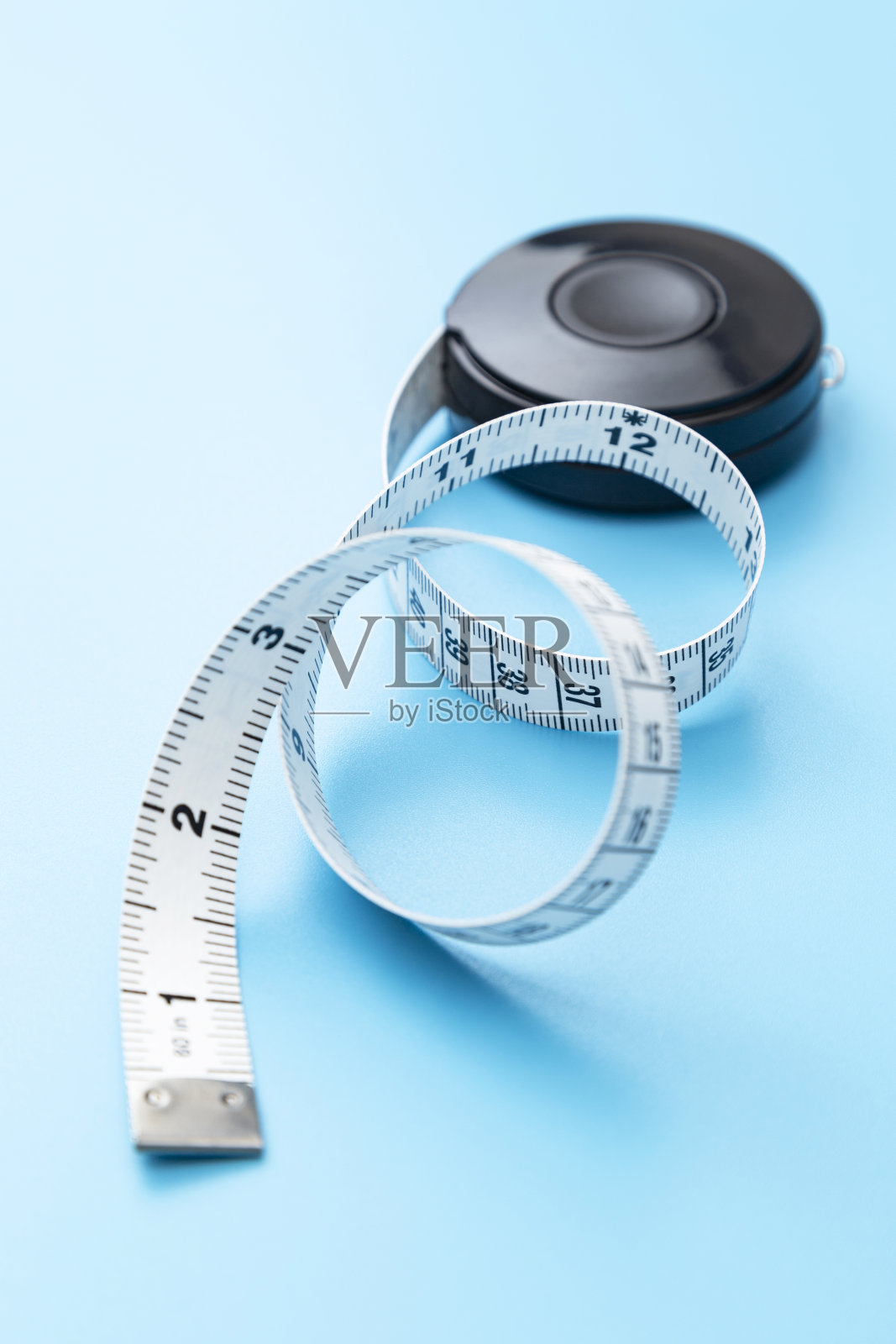 卷尺在蓝色背景上测量。照片摄影图片