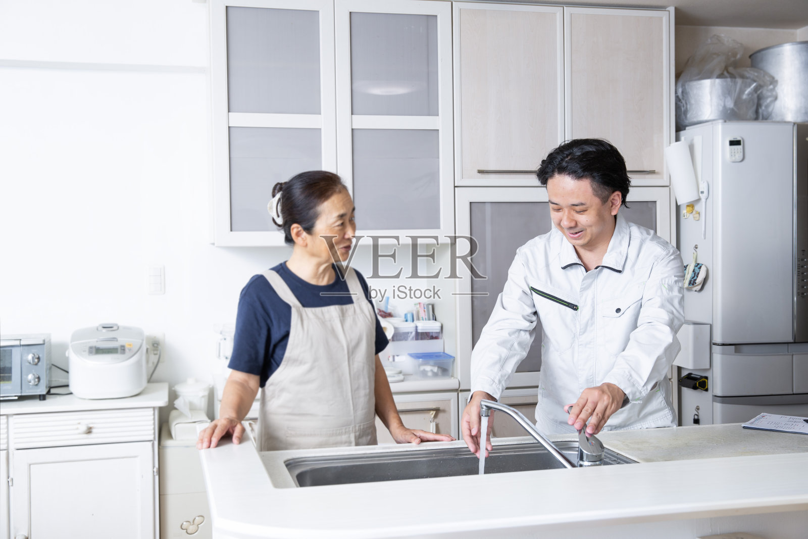 一名在小贩处工作的日本男子向顾客解释照片摄影图片