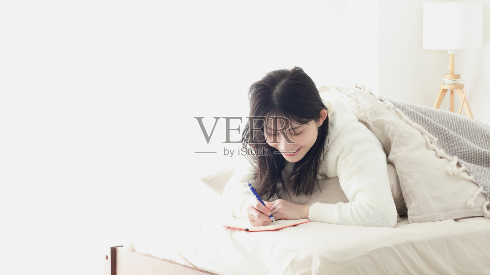 亚洲女人睡觉时记笔记照片摄影图片