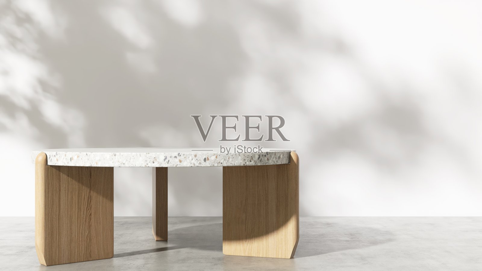 最小的彩色水磨石讲台桌,木腿,在斑驳的阳光下,叶叶的阴影在白色的墙壁上照片摄影图片