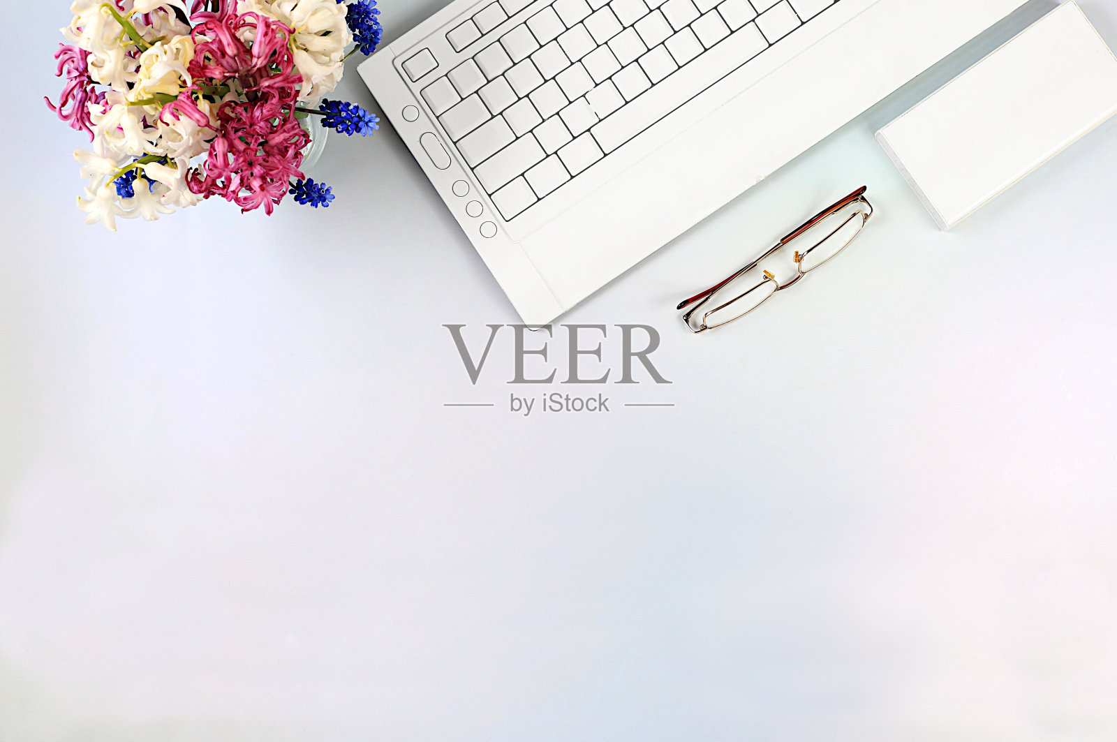 现代女性办公桌,家庭办公室。电脑,风信子花和智能手机放在优雅的桌子上,生活方式的概念,舒适的在家工作,模板的设计,平坦的放置,空间的文字照片摄影图片