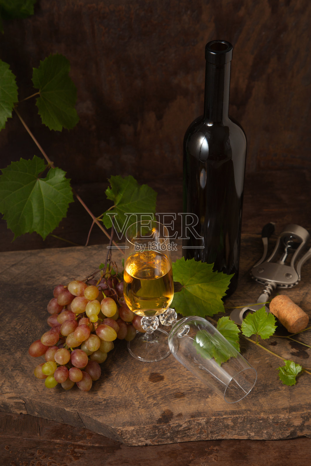 静物与白葡萄酒和葡萄酒杯在复古木制背景。照片摄影图片