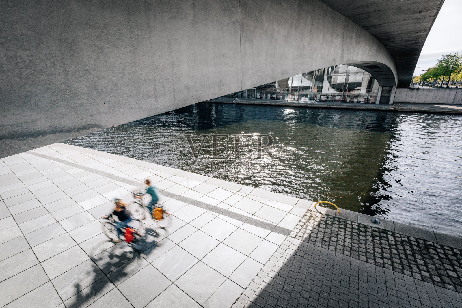 德国柏林施普雷河现代政府辖区下的骑行者照片摄影图片