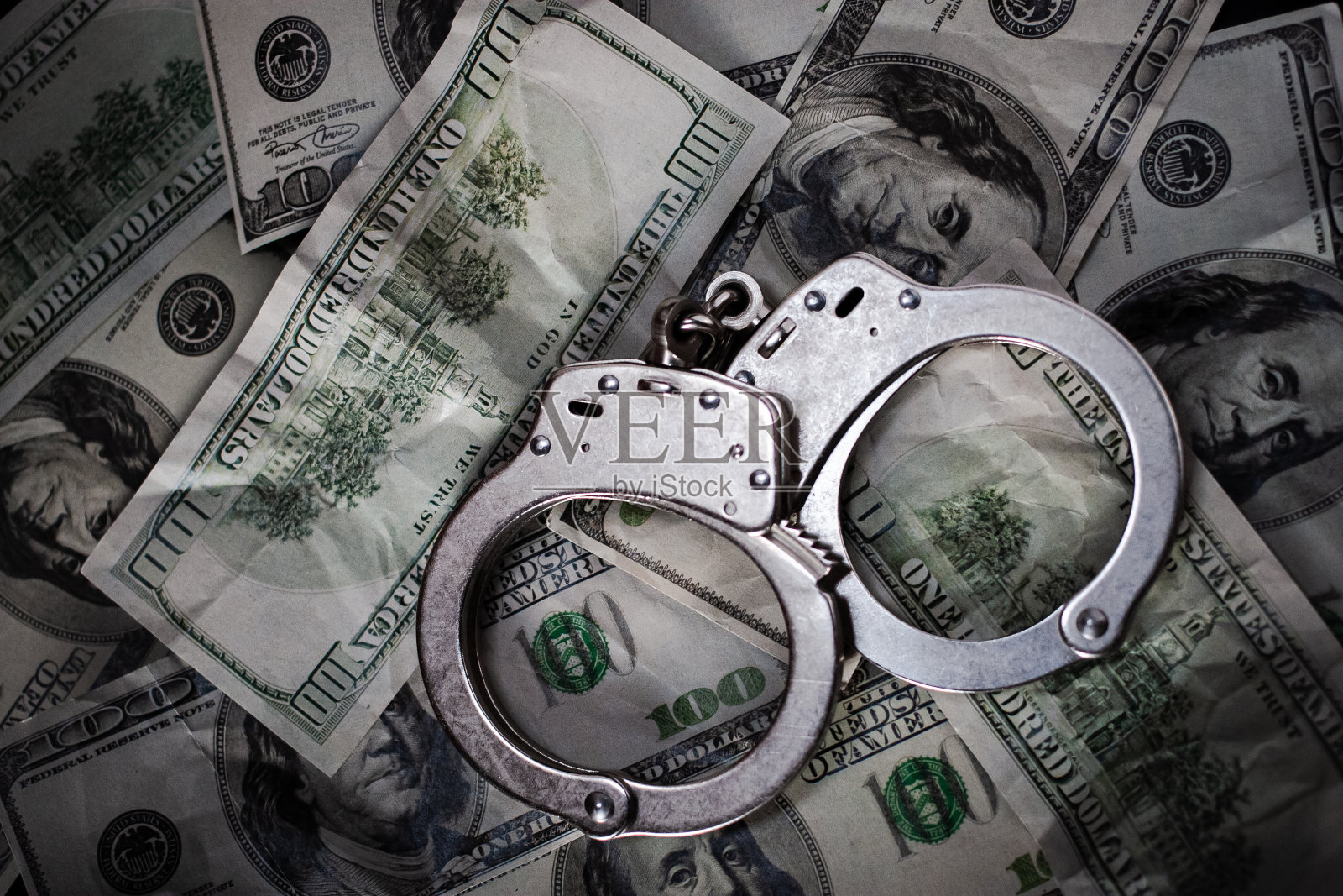 美元钞票上的手铐。照片摄影图片