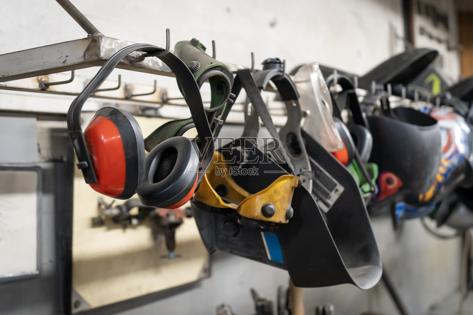 焊接车间内一排排挂着焊接头盔、防护眼镜、护耳照片摄影图片