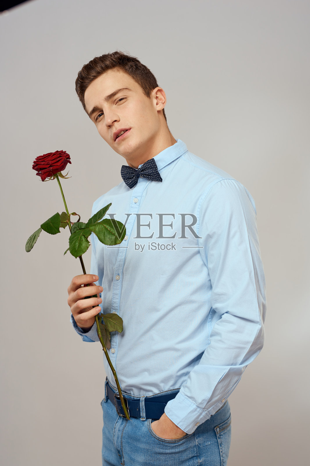 浪漫的男人与红玫瑰和浅色衬衫裤子西装照片摄影图片