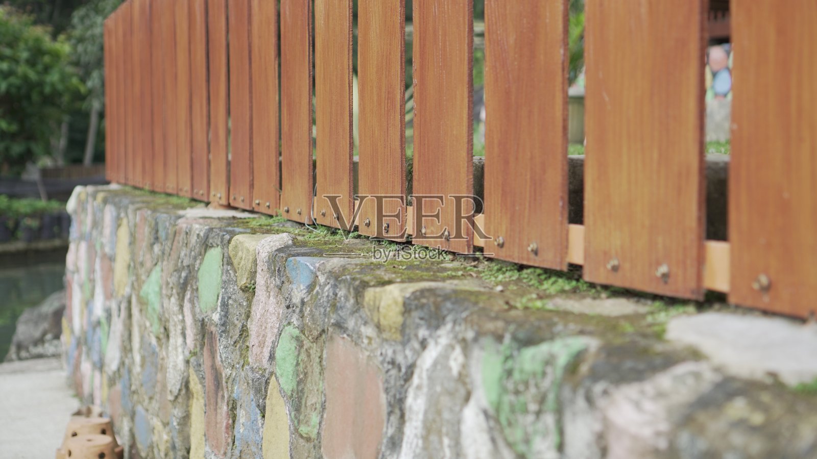 一个带有治疗涂层的木栅栏安装在岩石悬崖上照片摄影图片