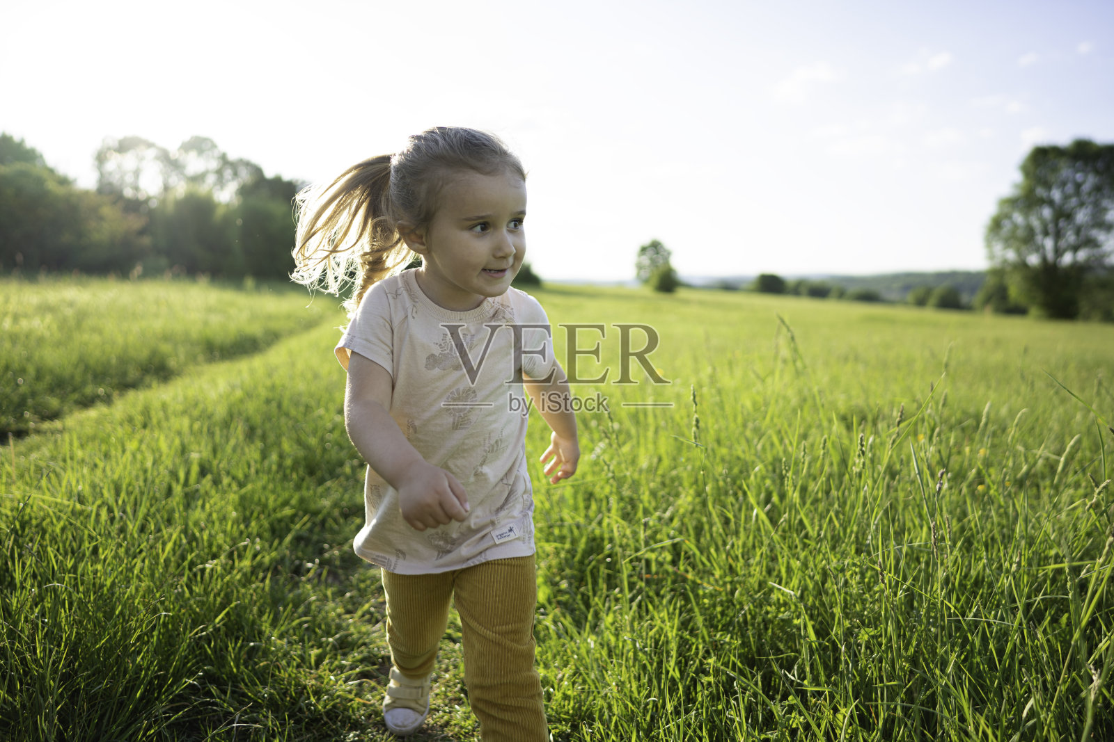 日落时分在大自然中奔跑的快乐女孩,复制空间。照片摄影图片
