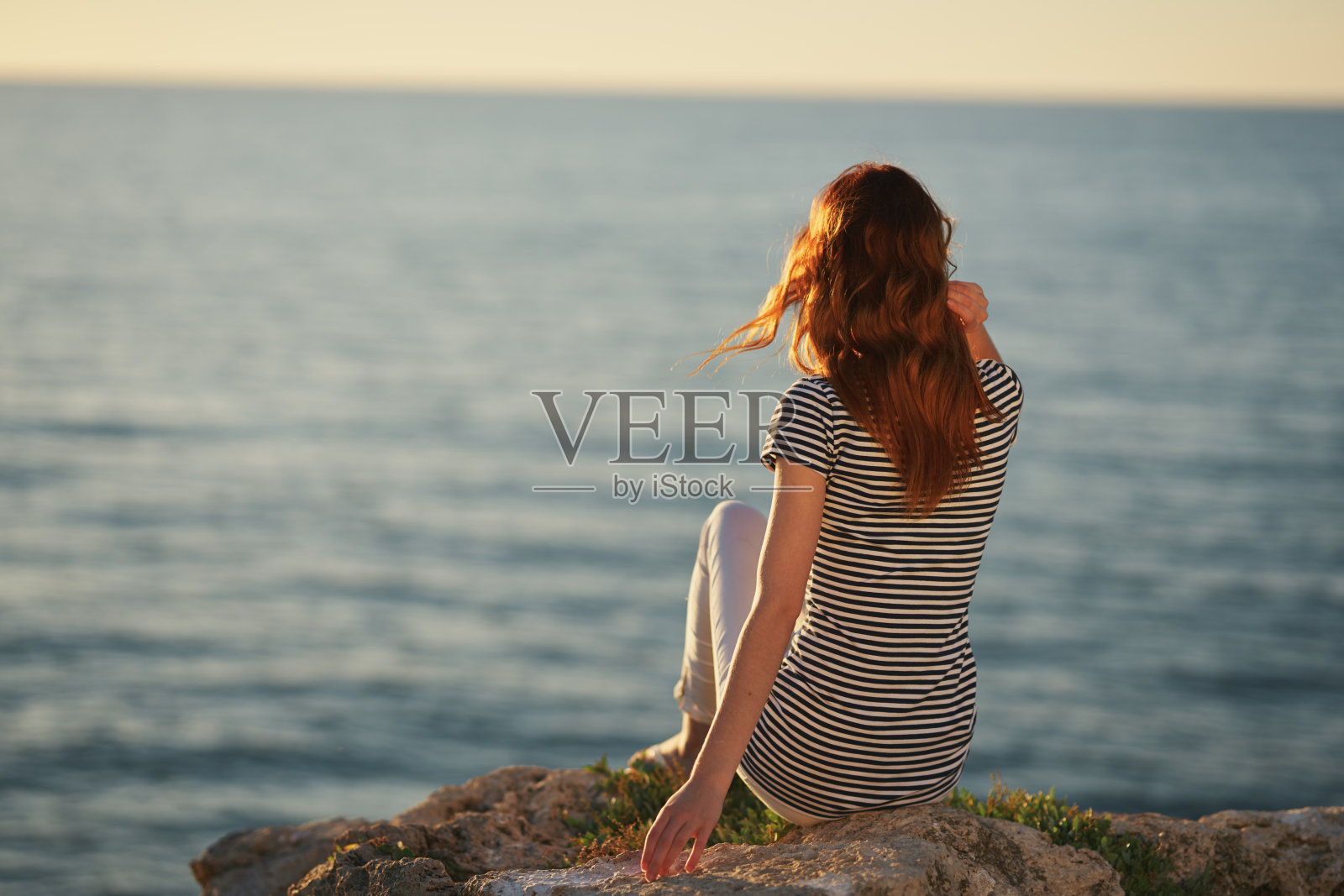 日落时海边的旅行者的背影照片摄影图片