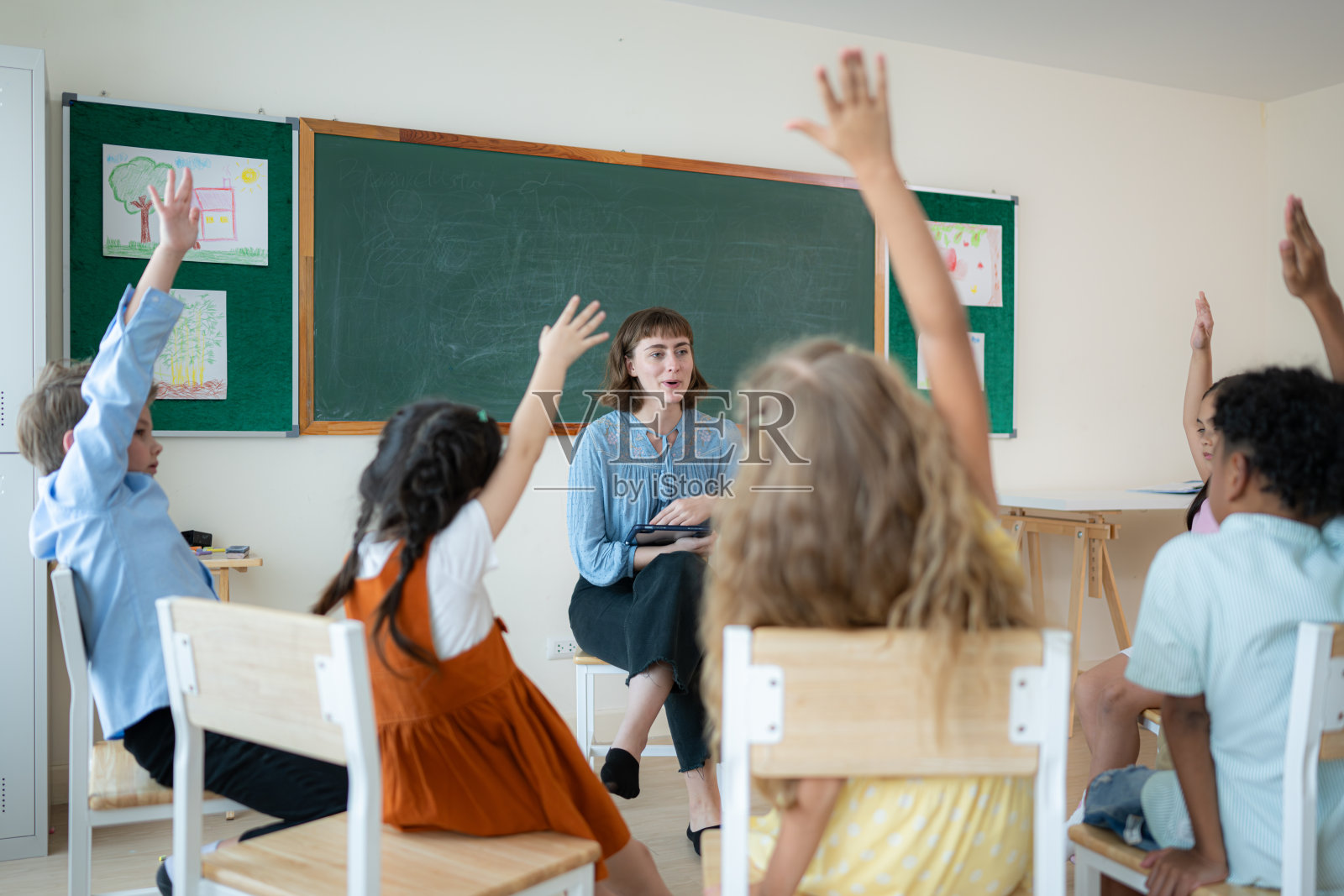 老师和学生,在学校的教室里学习,孩子们坐在那里专心地听。照片摄影图片