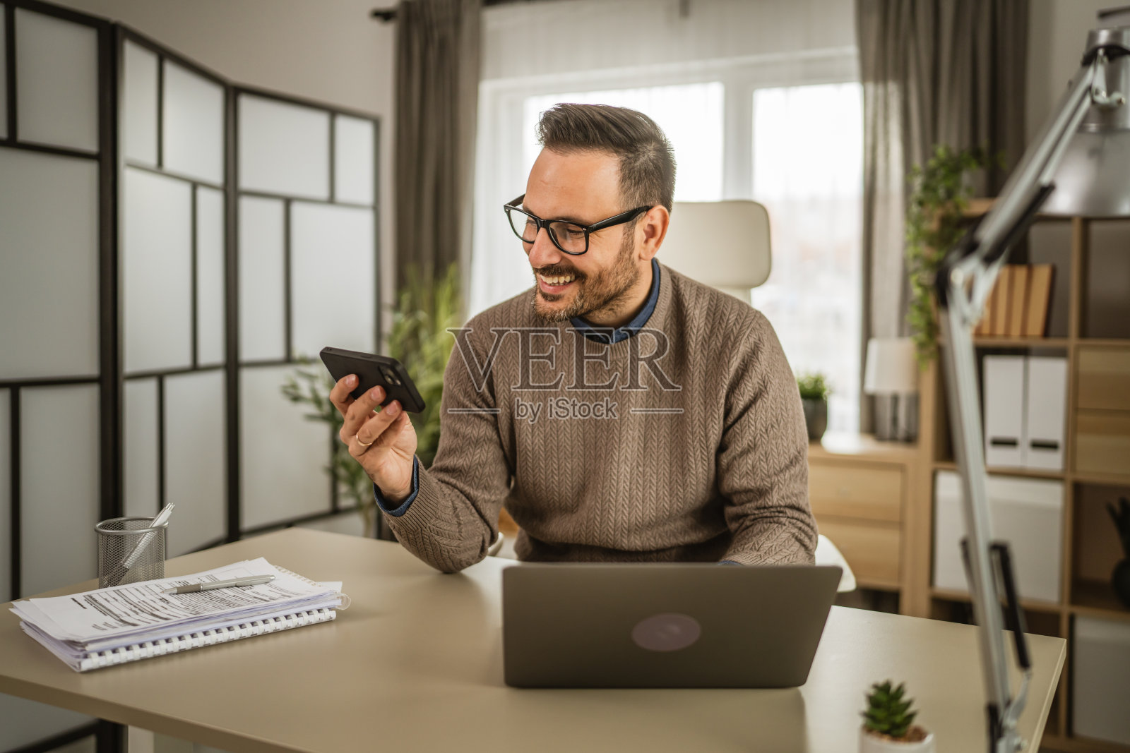 成年男子在工作之余玩手机游戏照片摄影图片