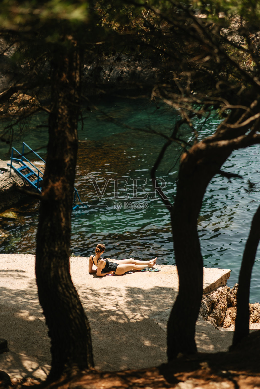在海边晒日光浴的女人照片摄影图片
