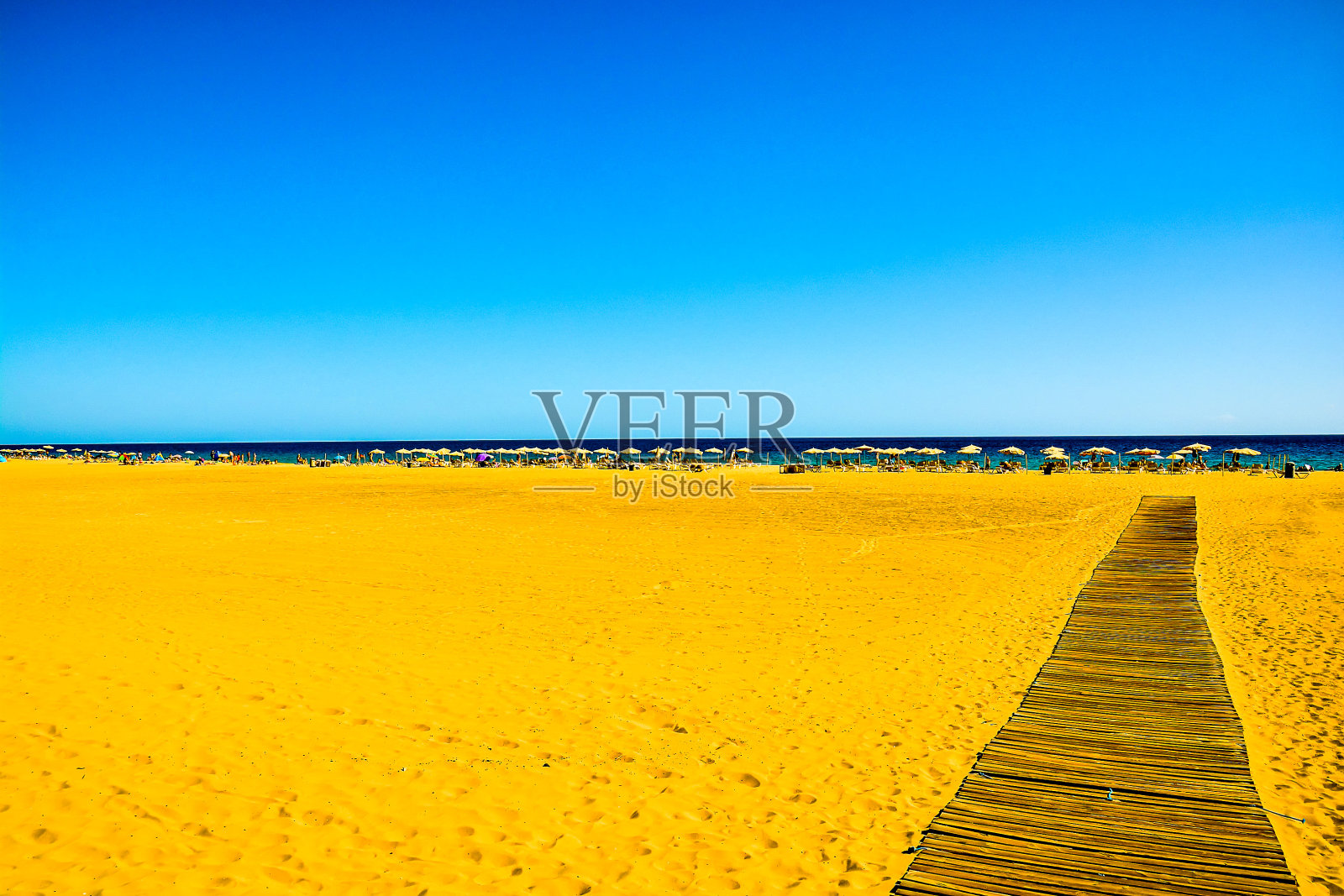 有一条长长的木板路通向水面的海滩照片摄影图片