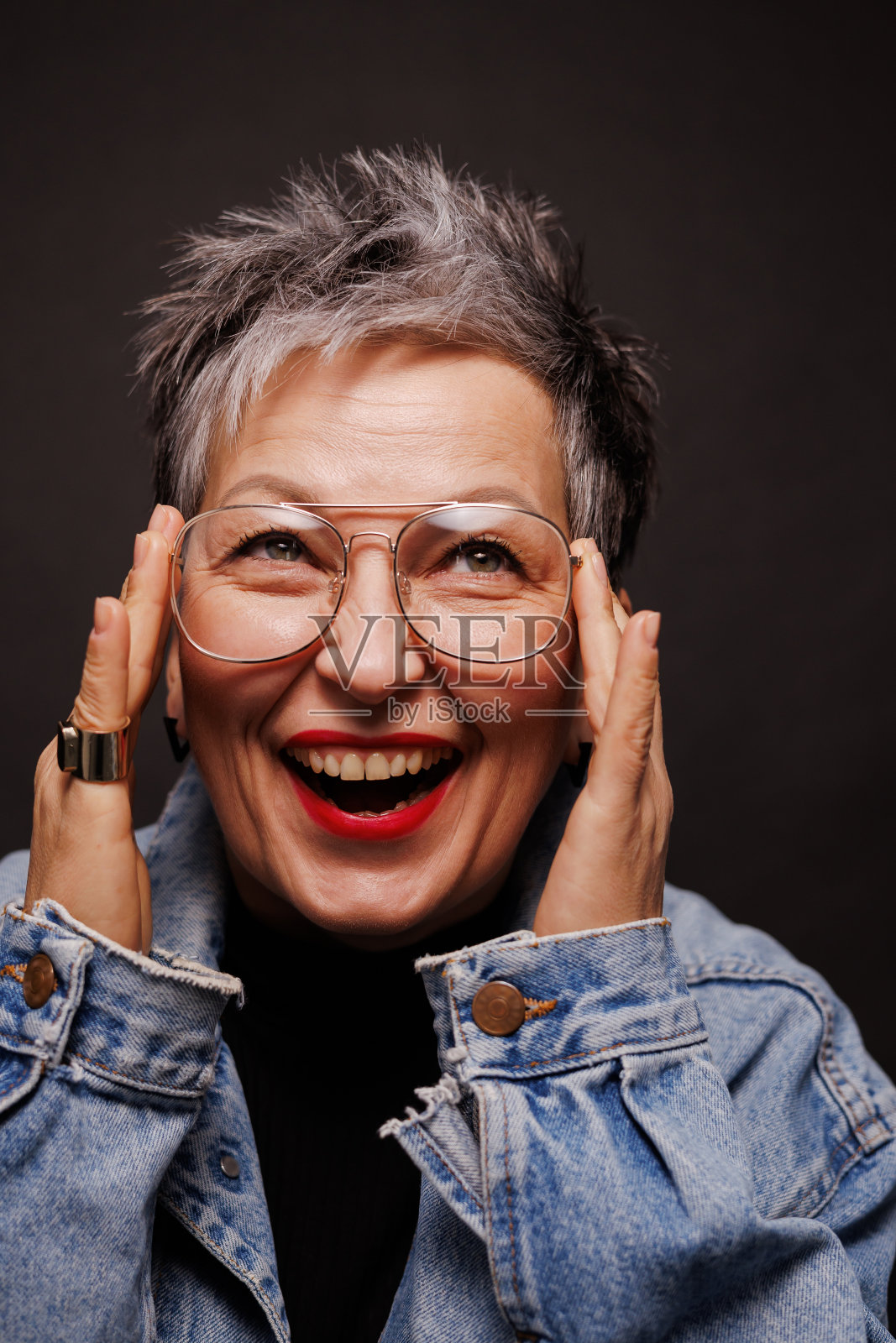 肖像开朗和时尚的成熟女子与红唇触摸眼镜孤立的黑色照片摄影图片