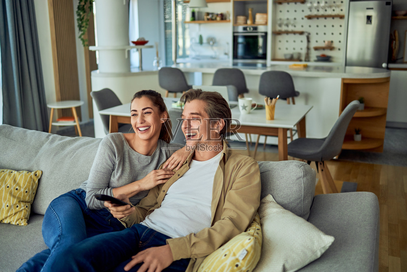 一对幸福的夫妇坐在客厅的沙发上看电视照片摄影图片