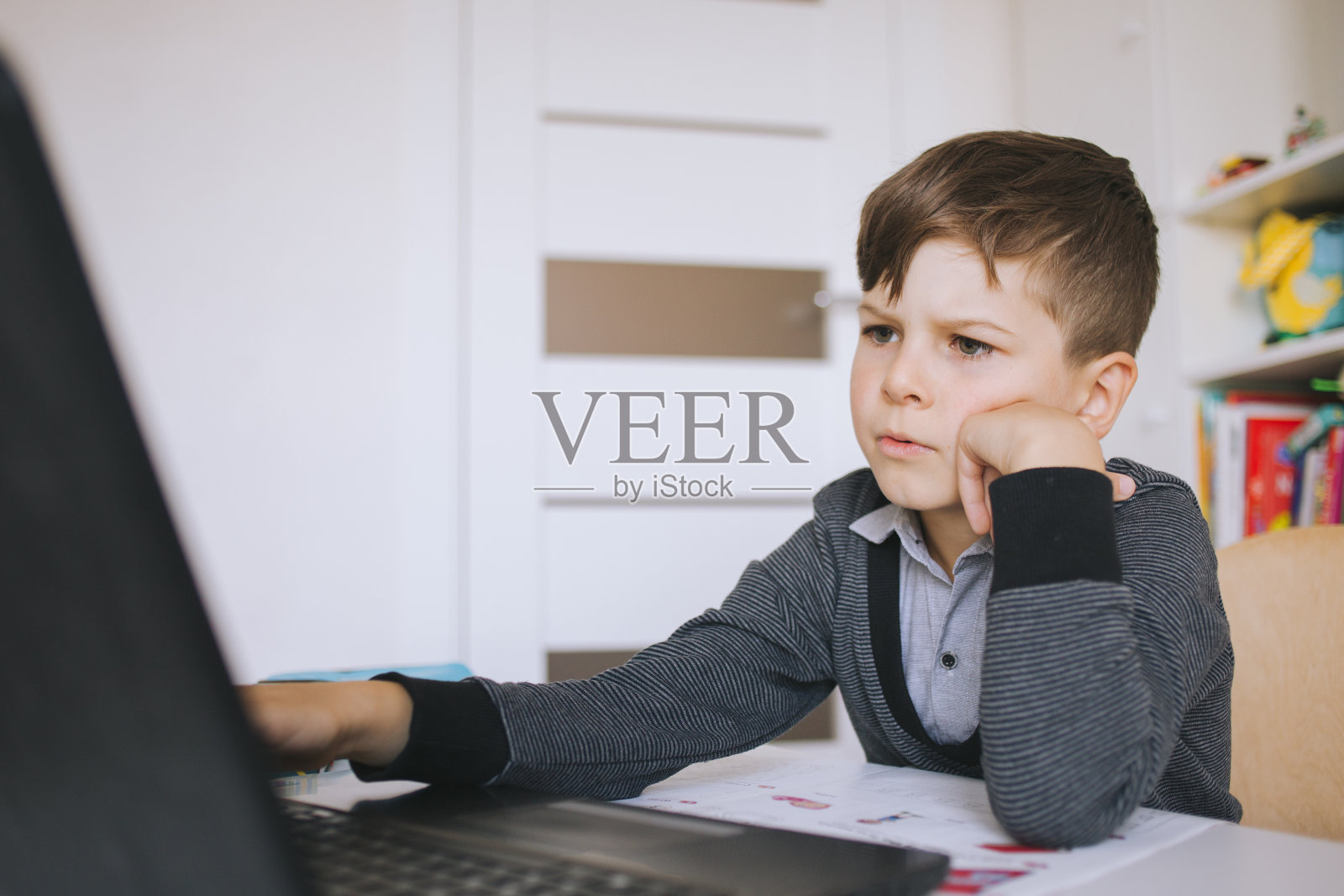 在线远程学习。男学生在家学习。小男孩在家里用笔记本电脑上网交流。在家上学,远程学习,在线学习。在线远程学习。一个学院照片摄影图片