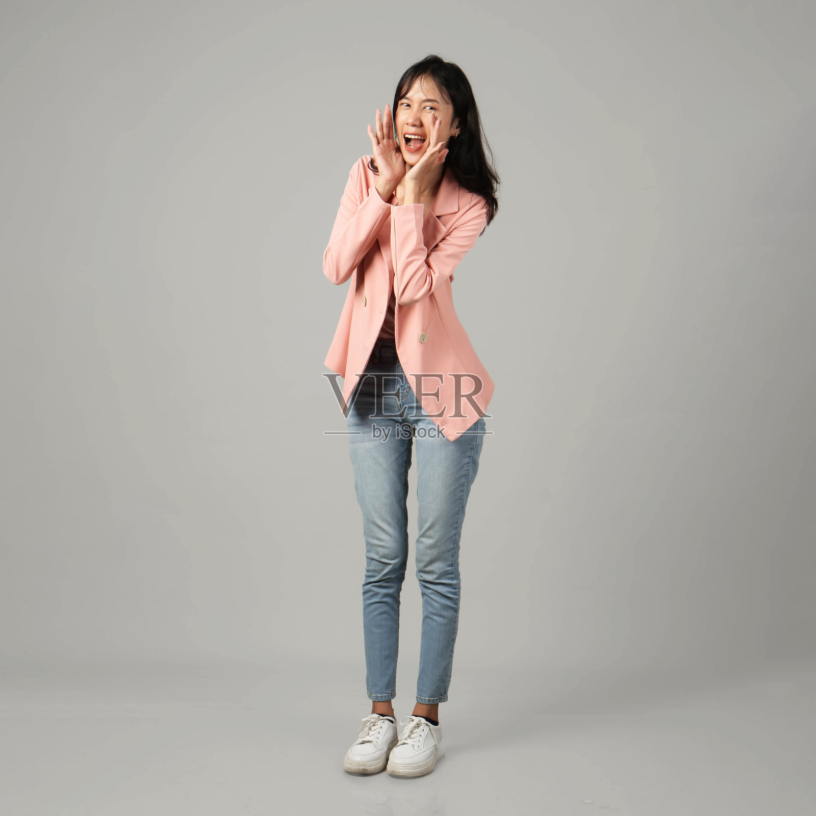 全镜头拍摄快乐的亚洲妇女喊着拔罐的手。在孤立的背景下穿着正式的休闲装照片摄影图片