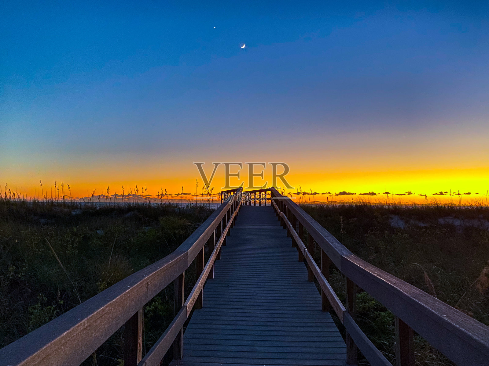 佛罗里达克利尔沃特海滩的木板路上日落的景色。照片摄影图片