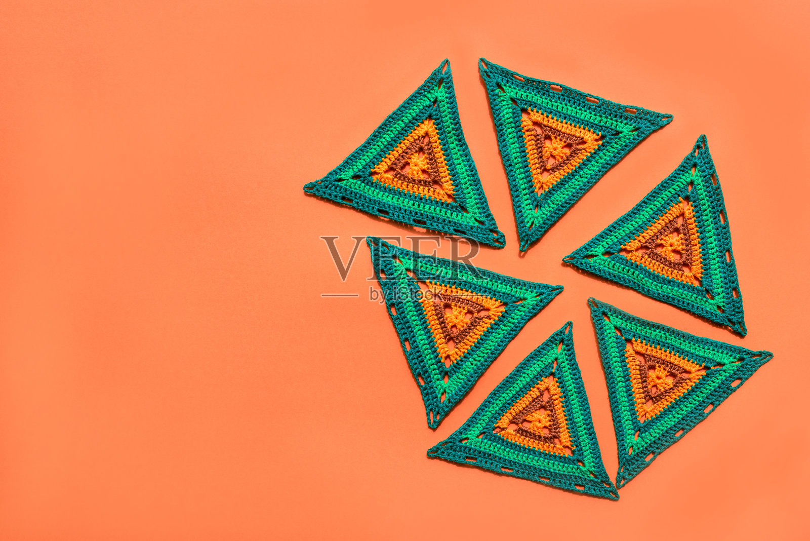 顶部视图的彩色钩针图案放置在橙色的背景。照片摄影图片
