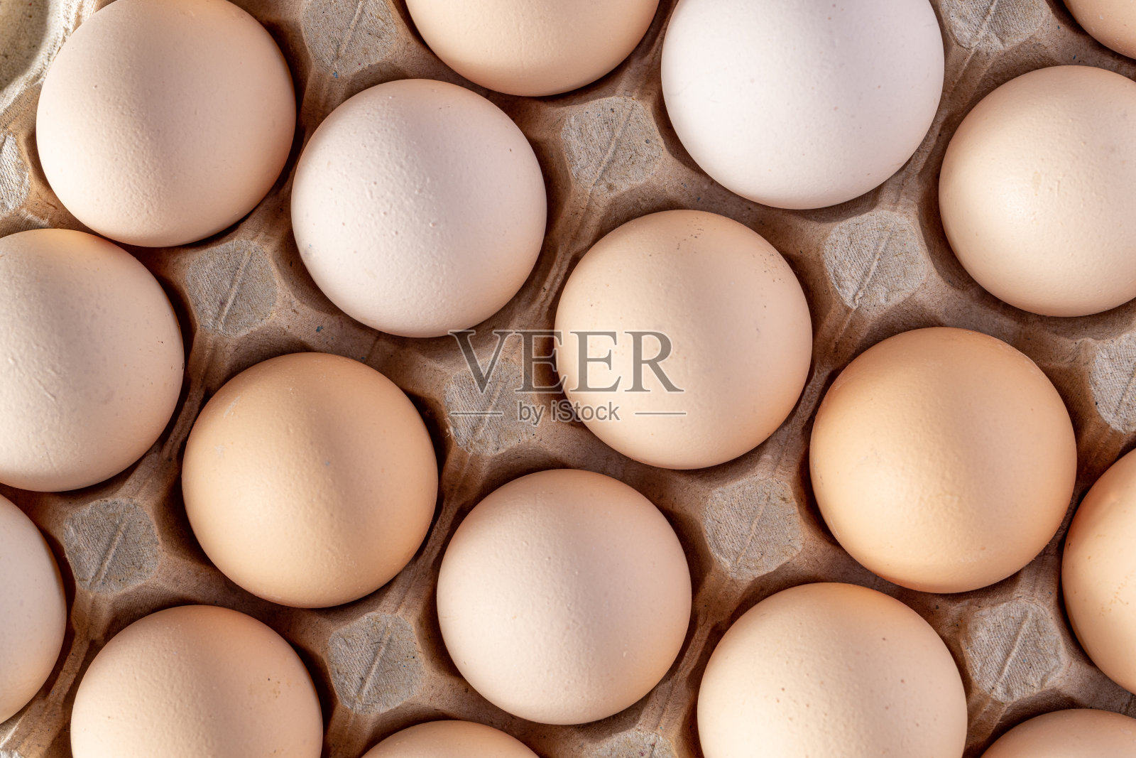 成排堆放的棕色鸡蛋。一组新鲜的白鸡蛋装在纸板盒里。来自大自然的有机食品对健康有益。照片摄影图片