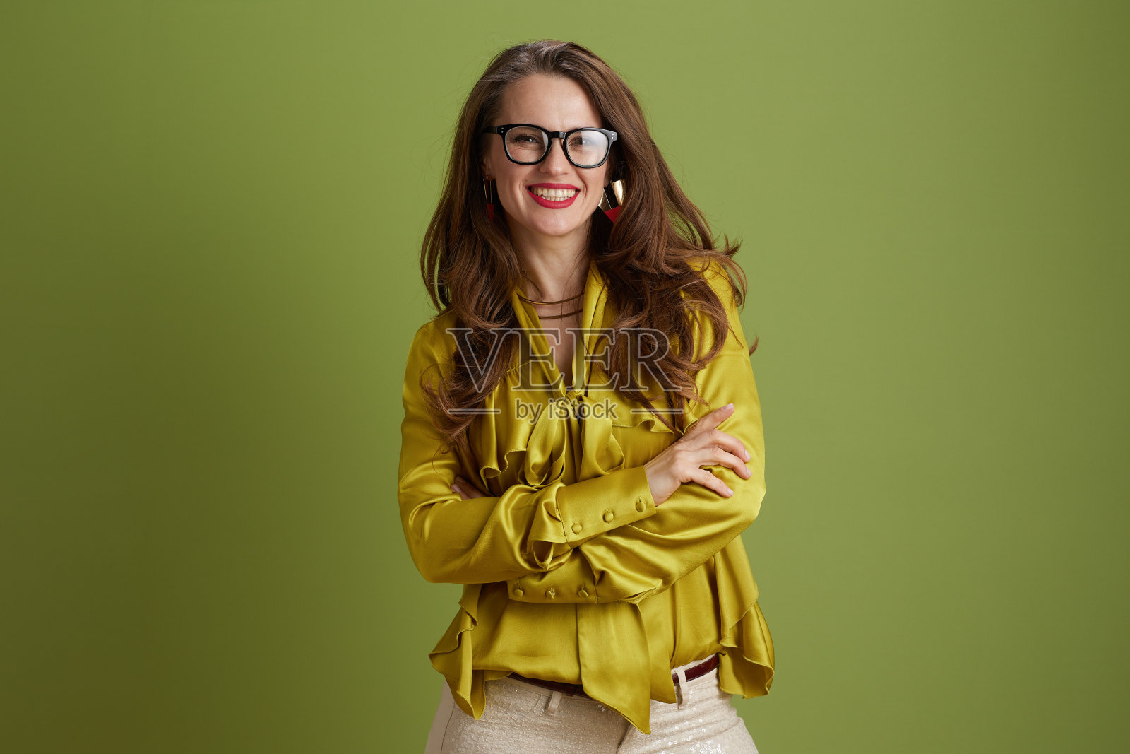 快乐的女人穿着绿色的上衣,戴着绿色的眼镜照片摄影图片