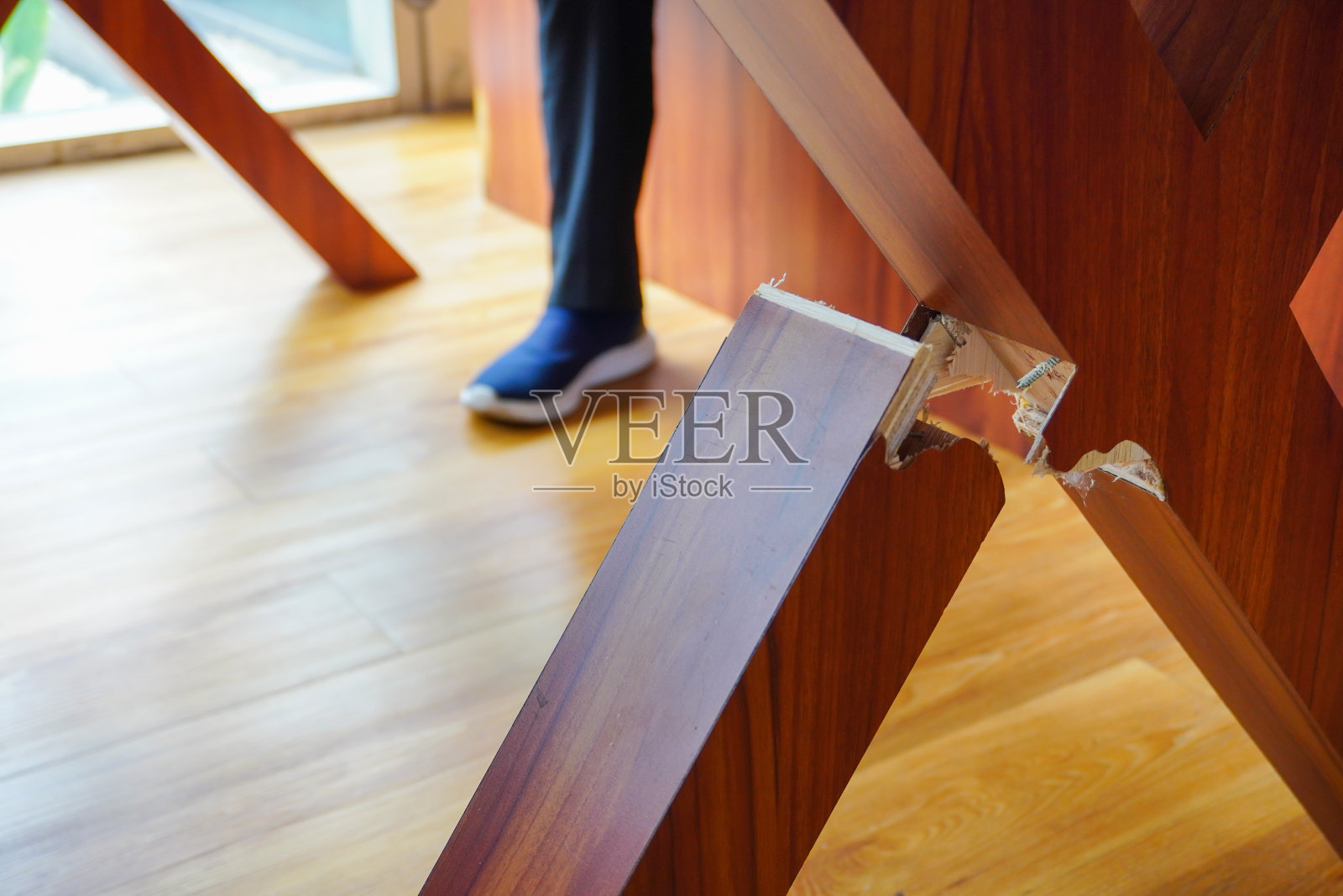 一条断了的木桌腿,加上一个坐着的人的模糊背景,形成了一种有趣的视觉对比照片摄影图片