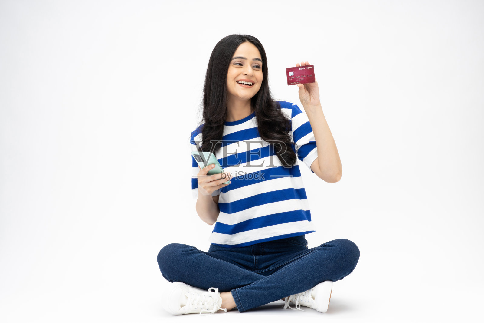 漂亮的年轻女孩的全尺寸照片坐在地板上网上购物穿着时髦的服装孤立的白色背景股票照片照片摄影图片