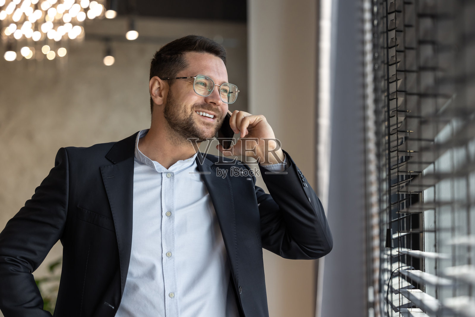 穿着西装的自信男子正在用手机聊天照片摄影图片