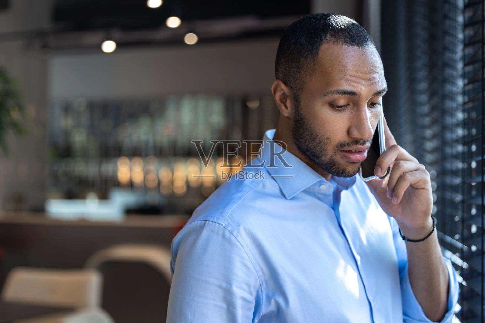 咖啡店里靠窗讲手机的黑人照片摄影图片