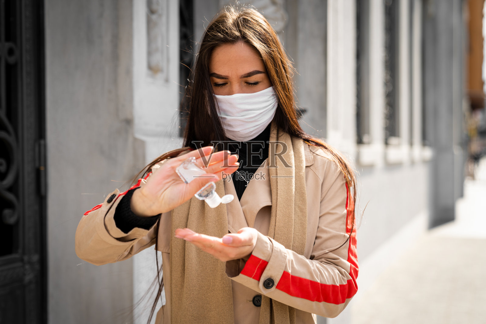妇女在户外使用抗菌洗手液-库存照片照片摄影图片