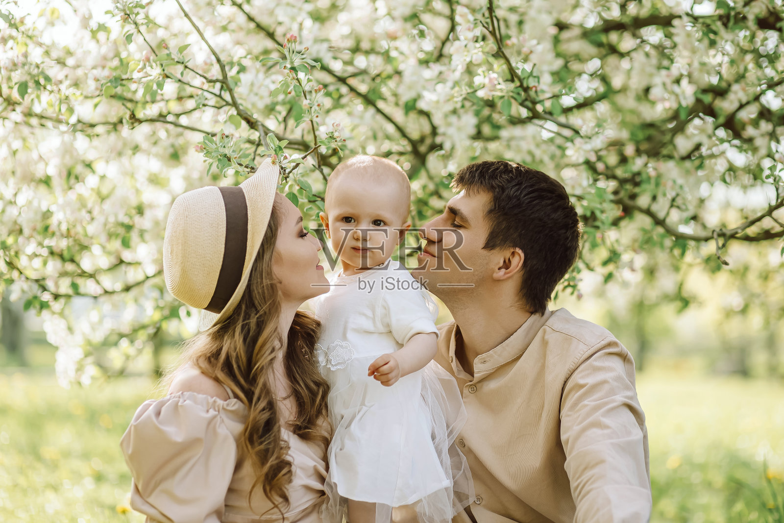 美丽的母亲和戴着帽子的女儿和父亲在野餐照片摄影图片