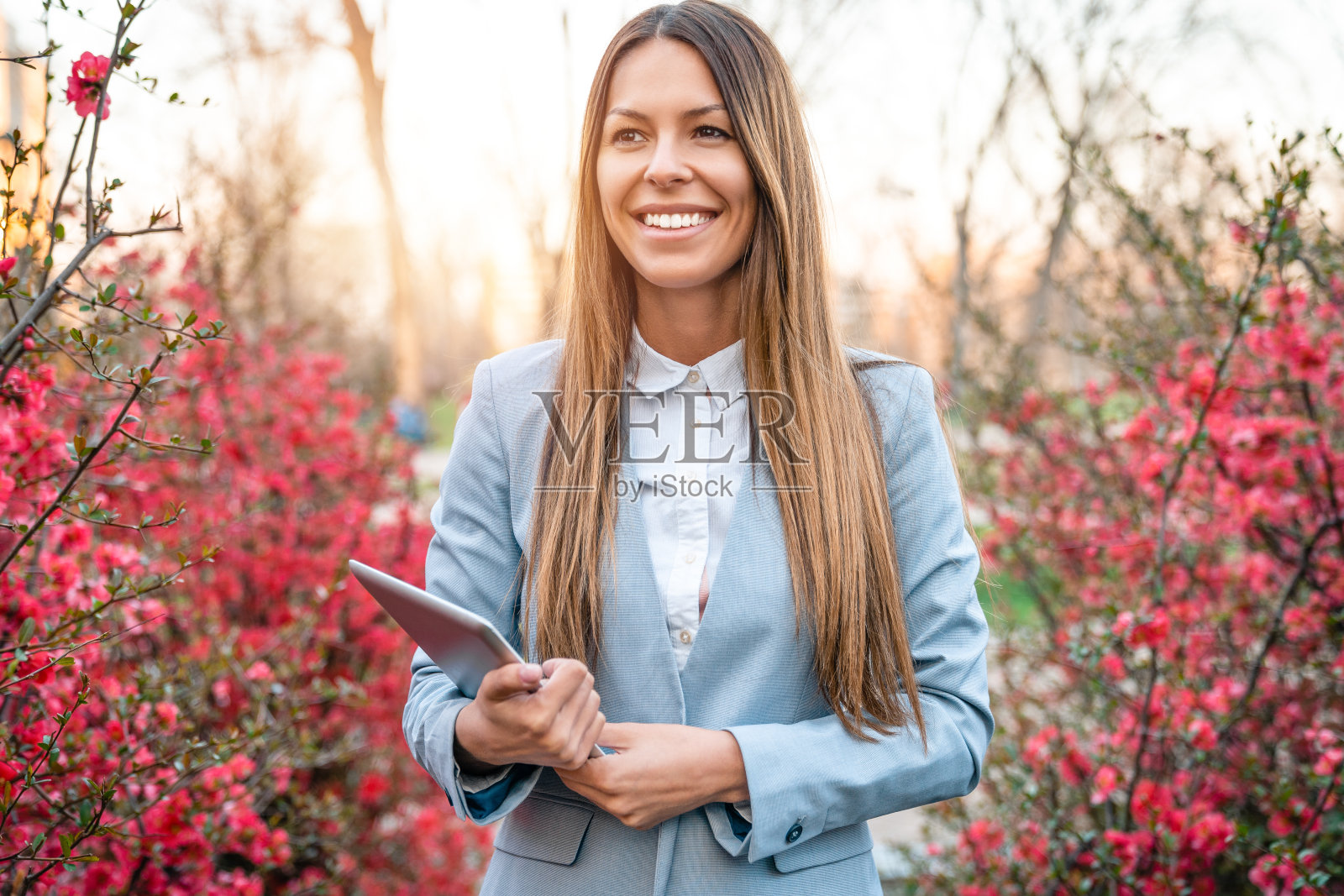 快乐积极的女商人在春天散步在公园里照片摄影图片