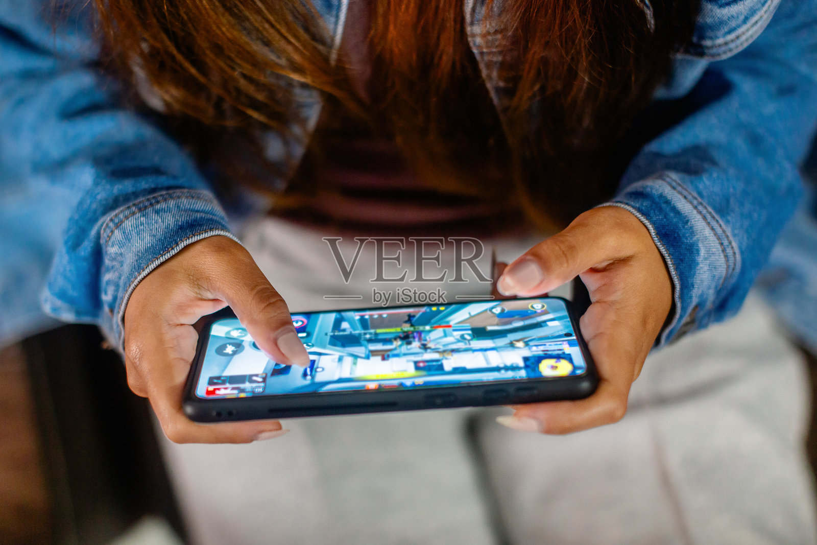 在棕色沙发上使用智能手机的女人的手特写。copyspace照片摄影图片