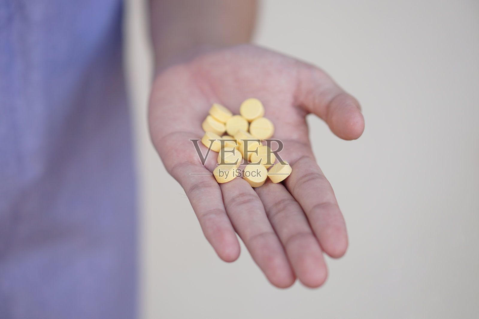 聚焦手中的黄色止痛药。概念、保健、治疗、缓解疾病和家庭自我疗法。服用过量药丸。照片摄影图片