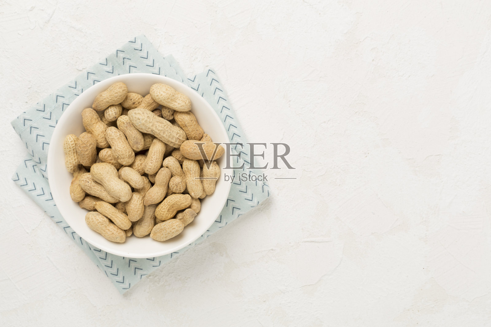 混凝土背景上未剥皮的花生,俯视图照片摄影图片