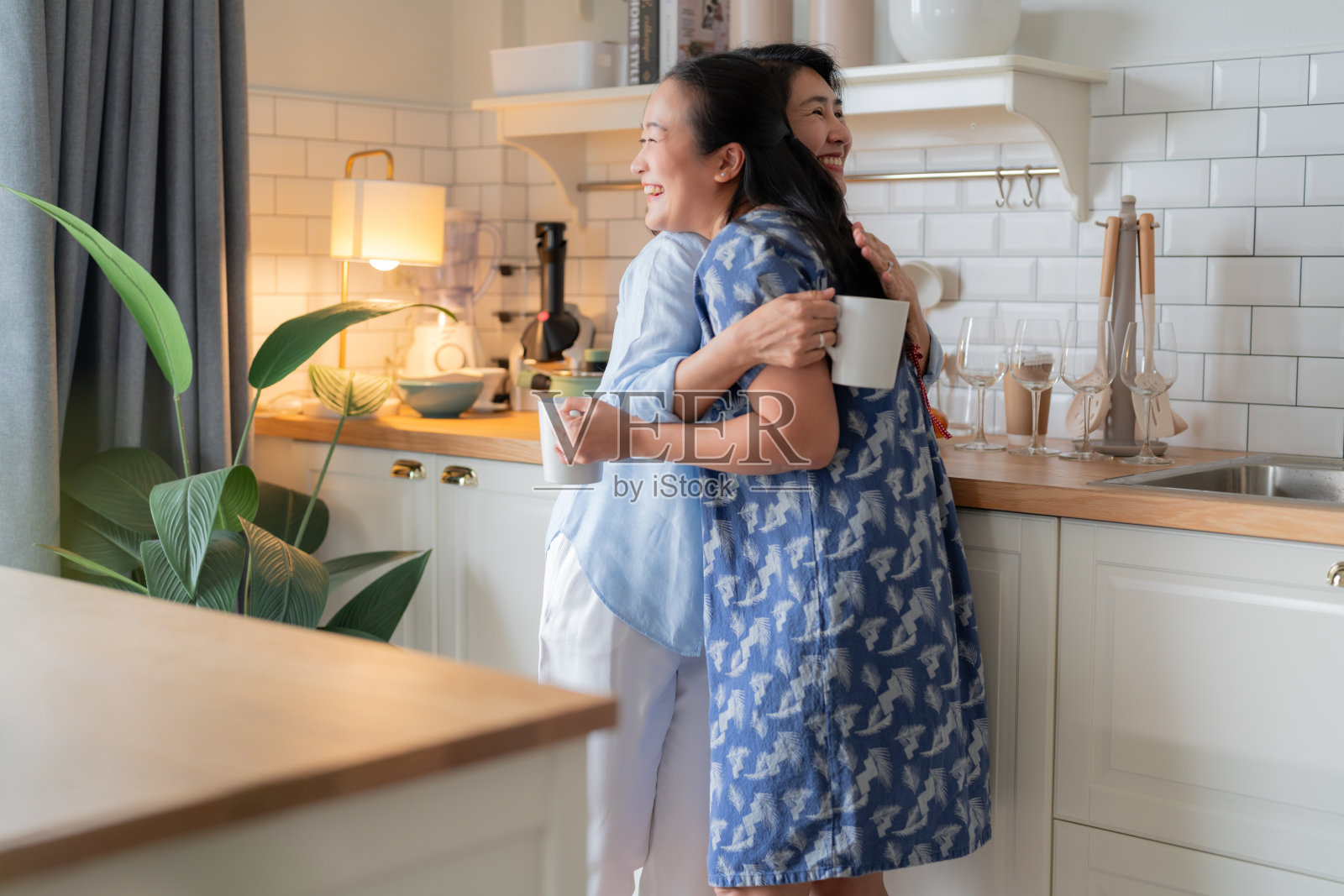 好老朋友回老家亚洲成熟女性朋友谈话站在厨房积极的谈话良好的关系友谊团聚家访随意放松手握咖啡杯在家里好气氛照片摄影图片