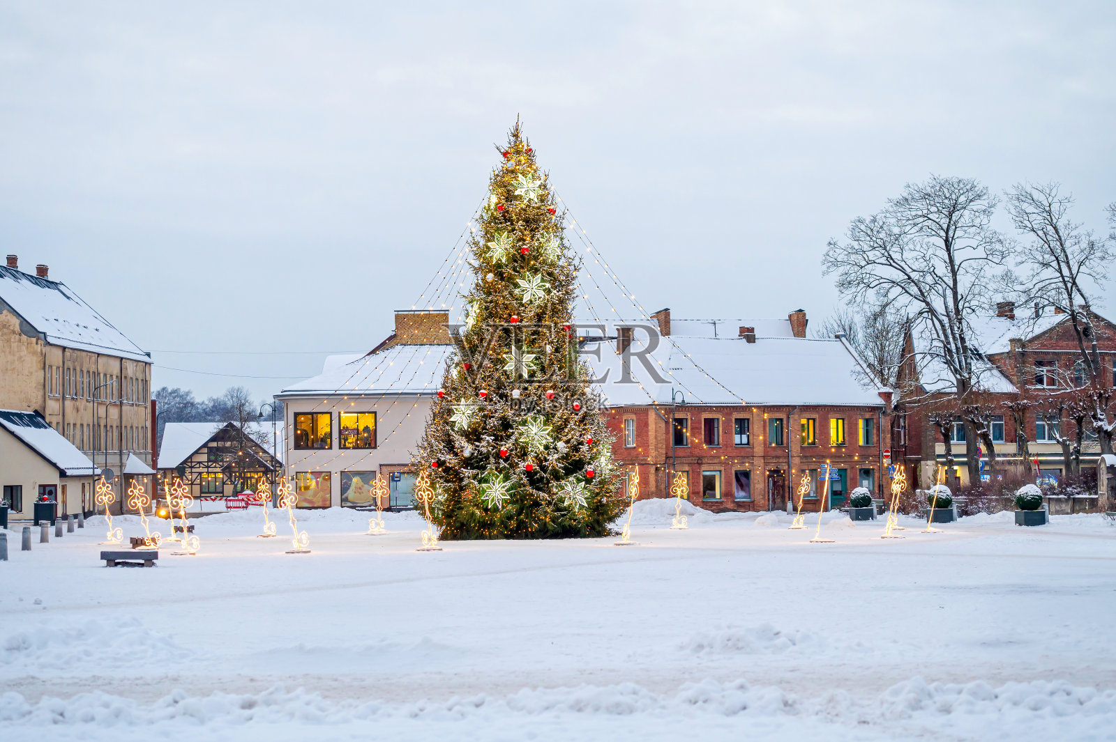 拉脱维亚多贝勒市广场上一棵装饰着装饰物和彩灯花环的圣诞树照片摄影图片