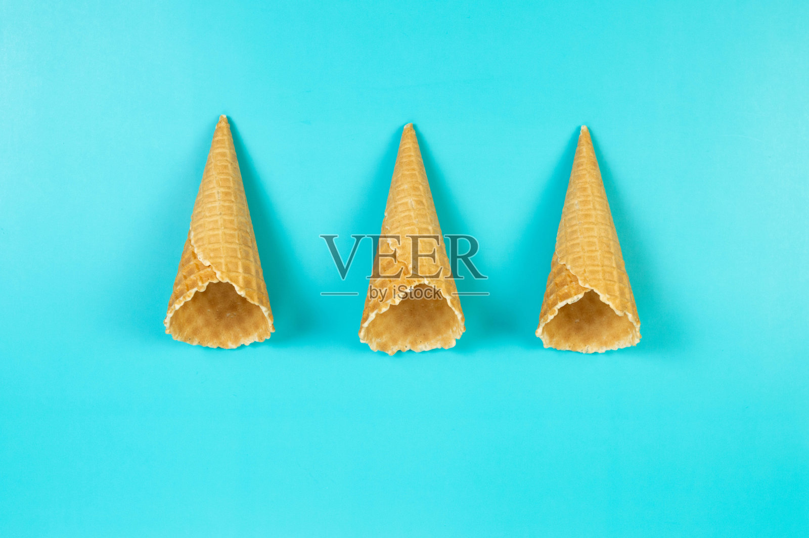 顶视图三个冰淇淋华夫蛋筒在蓝色的背景。照片摄影图片