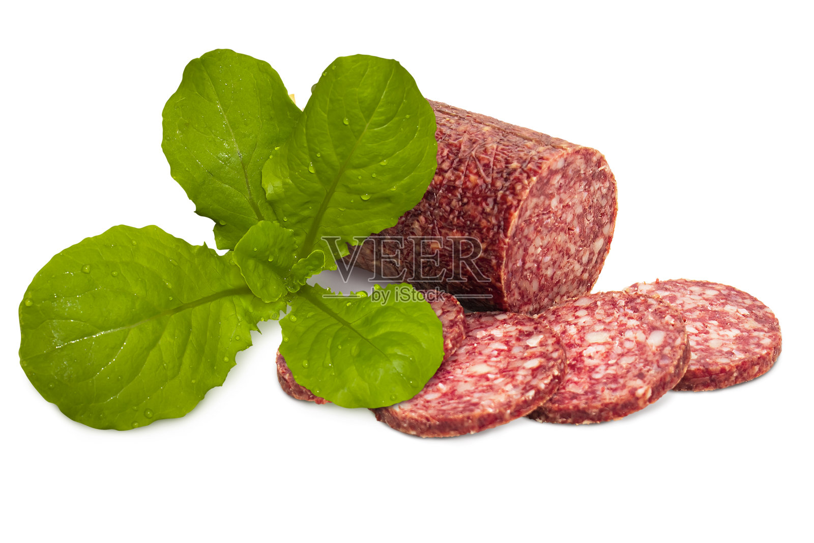 生熏肠旁边是新鲜的绿色沙拉叶。照片摄影图片