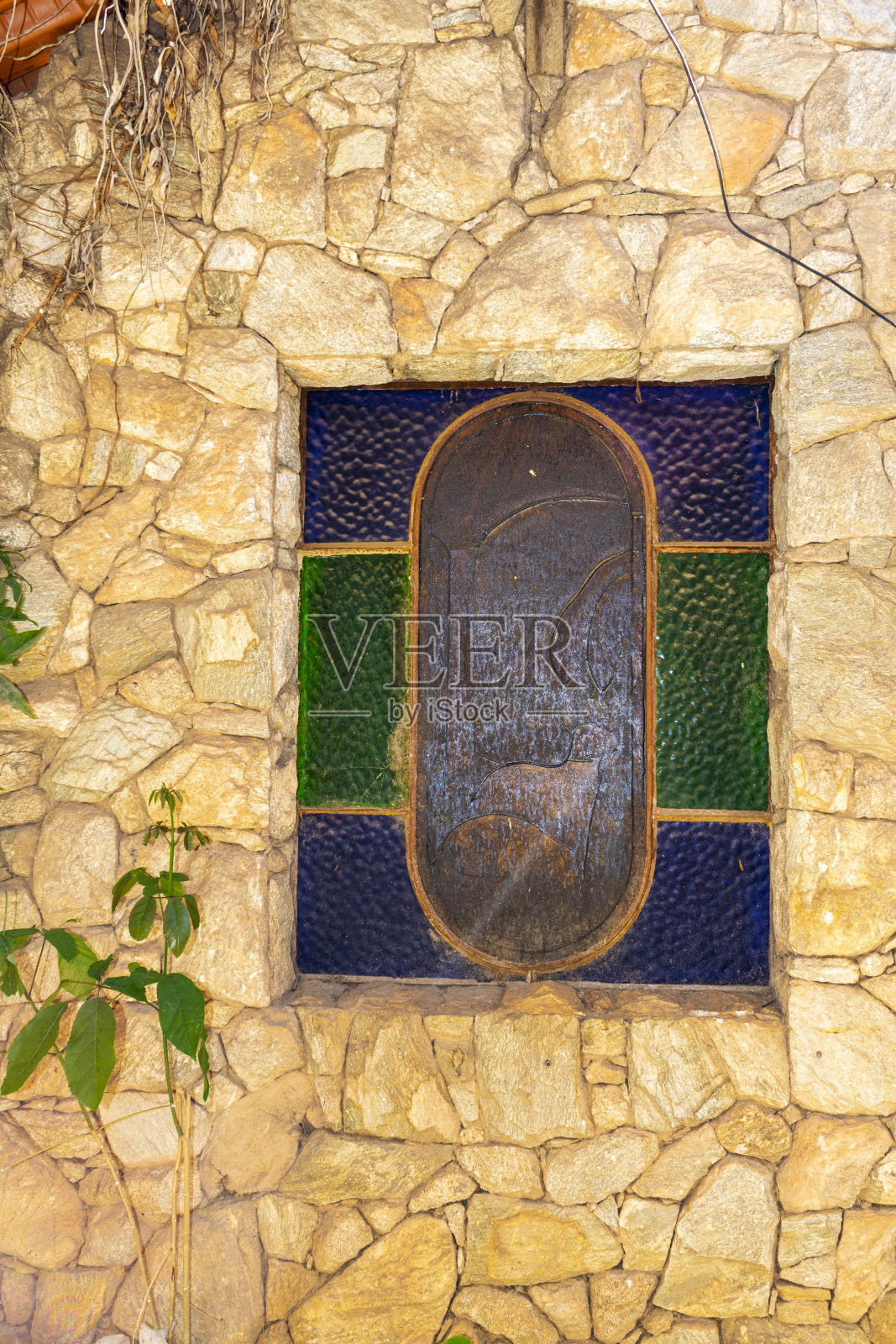 房子漂亮的石头立面上的玻璃窗。垂直的。照片摄影图片