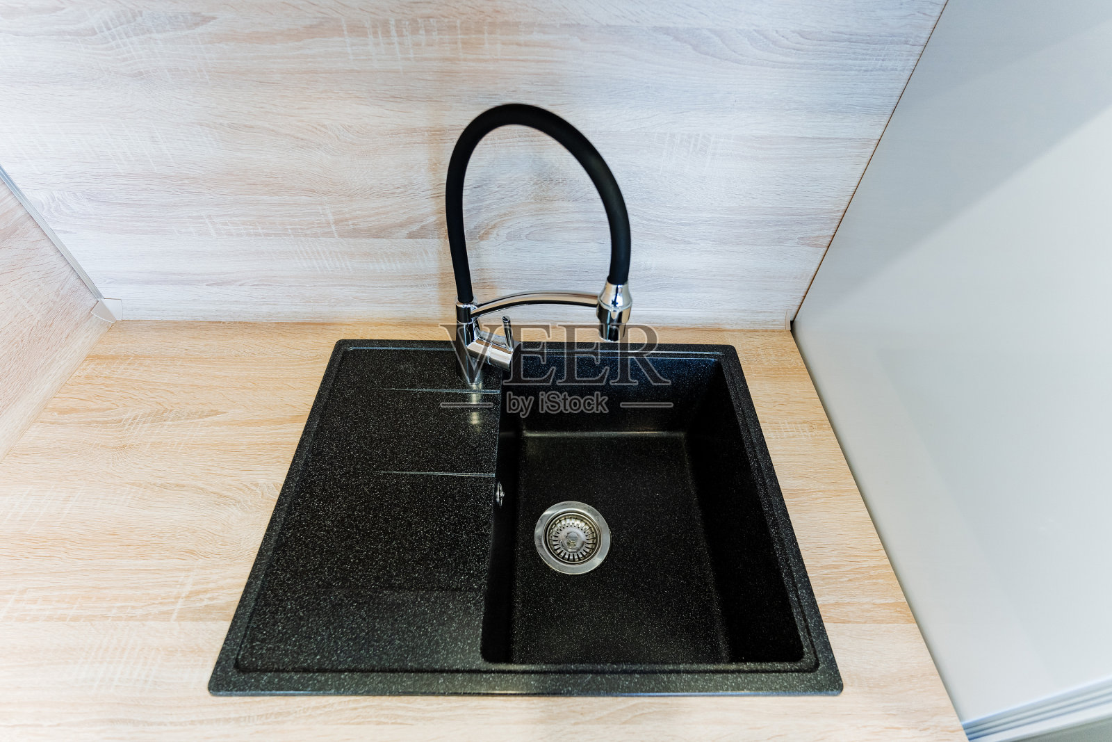 黑色矩形厨房水槽和木制台面上的水龙头照片摄影图片