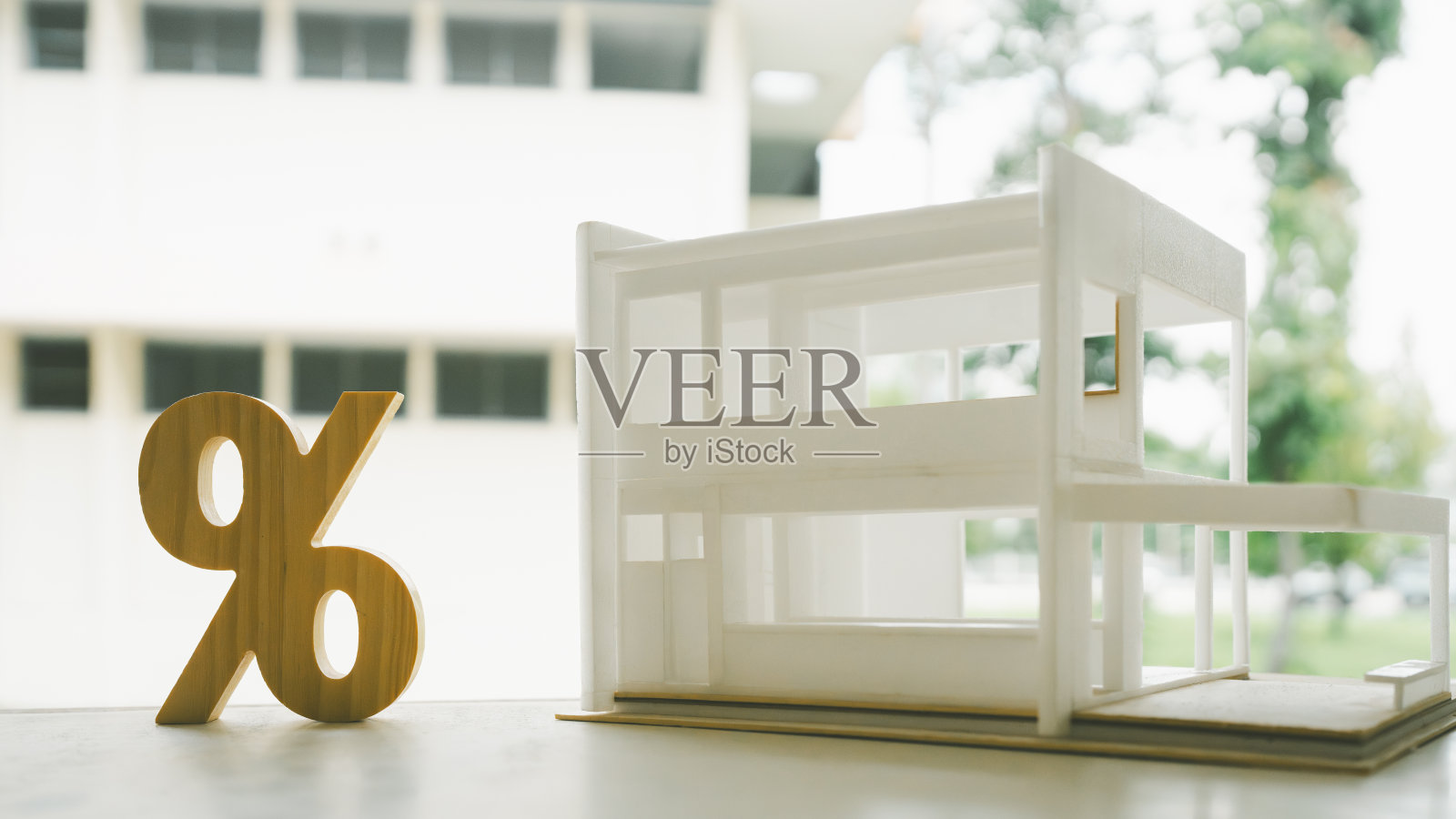 木桌上木质的百分比和房屋标志符号图标。房屋利息,房地产,通货膨胀投资的概念。照片摄影图片