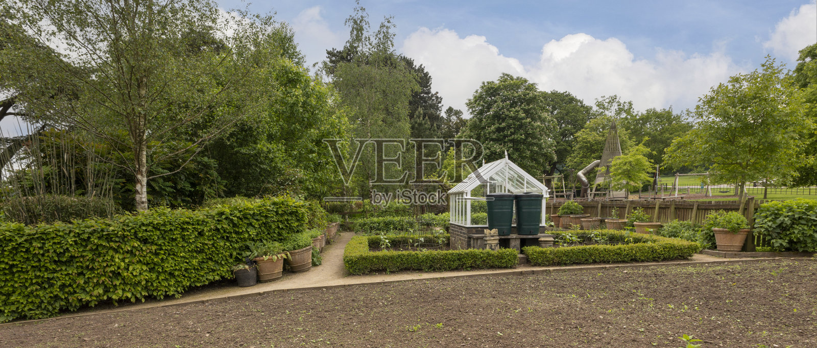 白色温室在一个小维护良好的菜园照片摄影图片