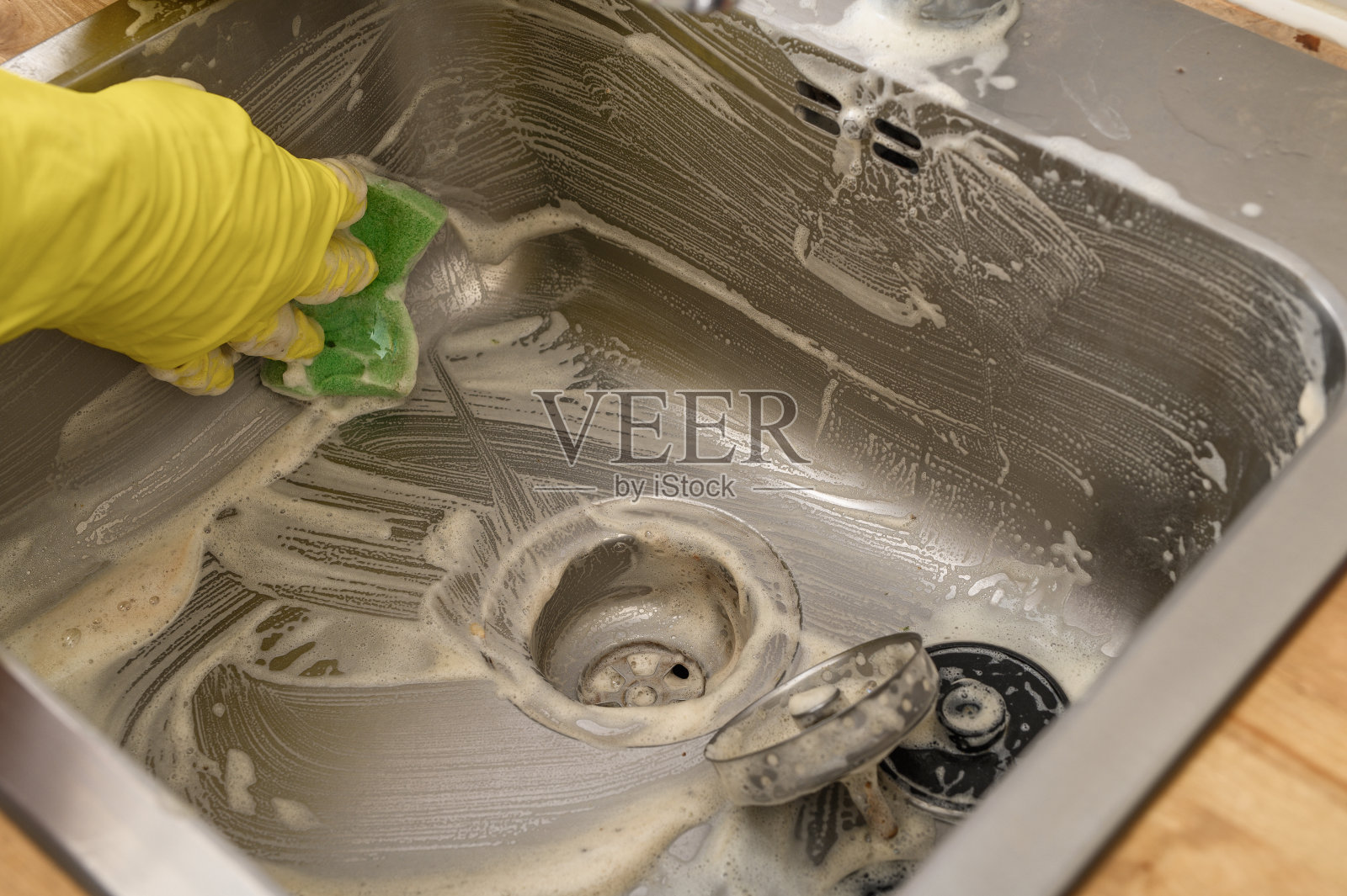 用海绵清洁和擦洗钢制水槽(特写)照片摄影图片